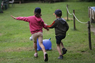 immagine di due bambini che giocano in un prato